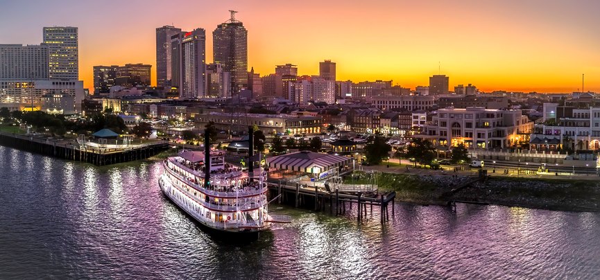 Sunset view of the Mississippi River with New Orleans in the background.